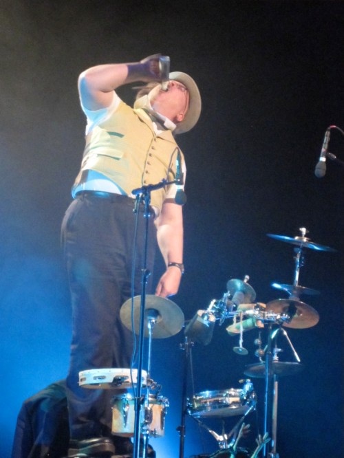 Adrian Huge's physical comedy extends to playing drums by spitting gumballs at them. 